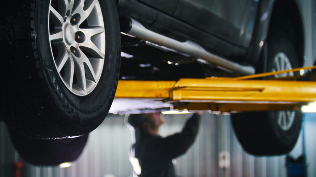 Car Lifted In Automobile Service For Fixing Worker Repairs Detail