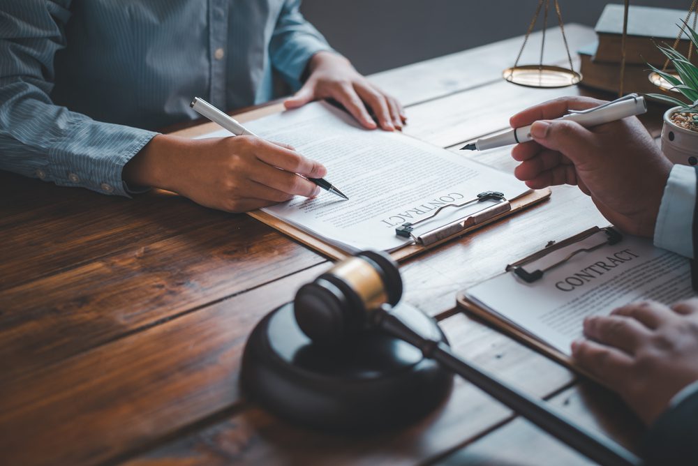 lawyer and person signing contract