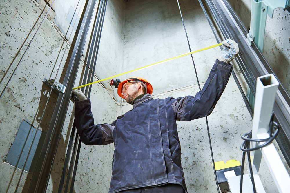 Machinist,With,Measure,Tape,Checking,Lift,Construction,In,Elevator,Shaft